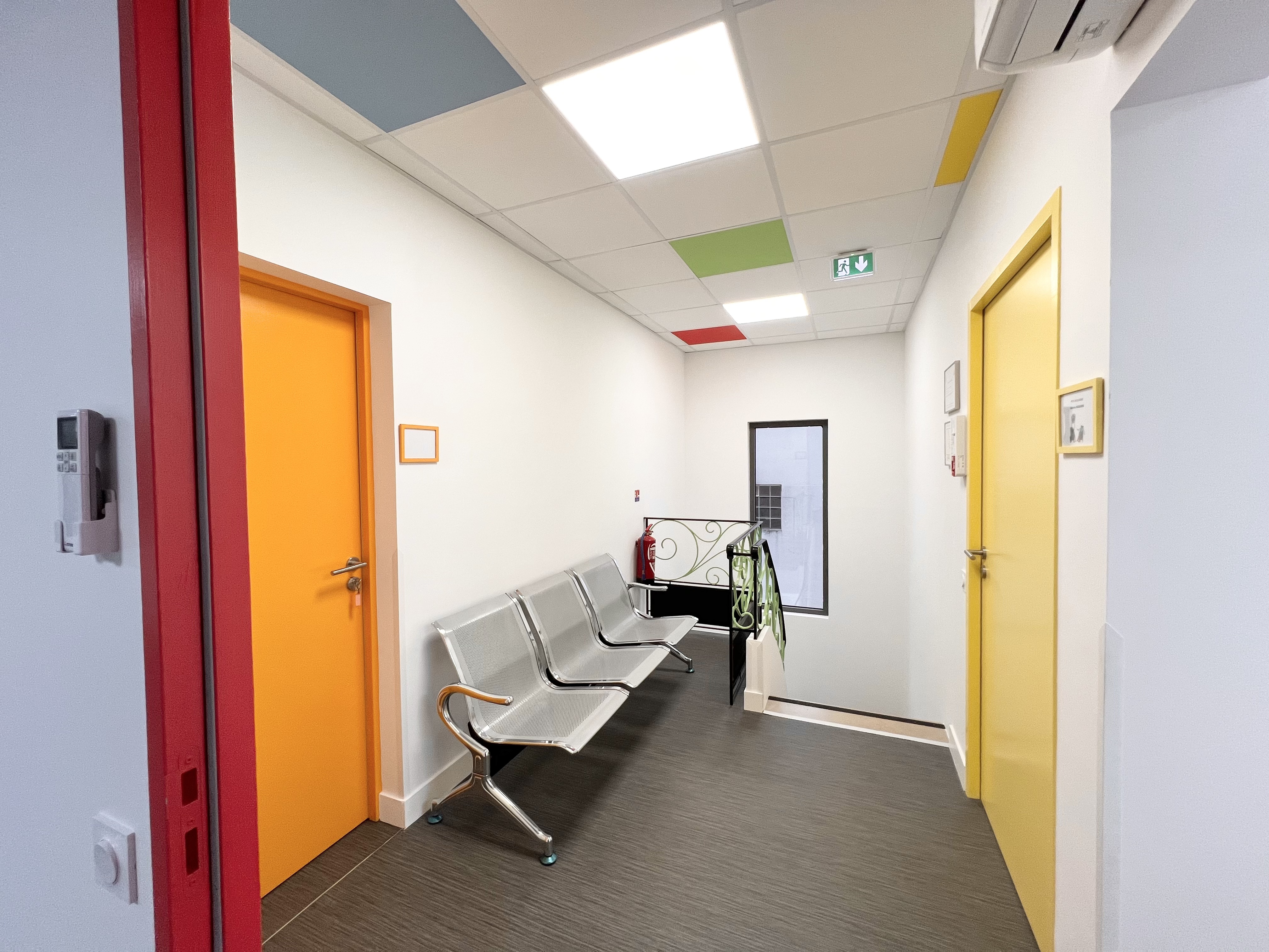 Salle d'attente du pôle médical avec portes colorées